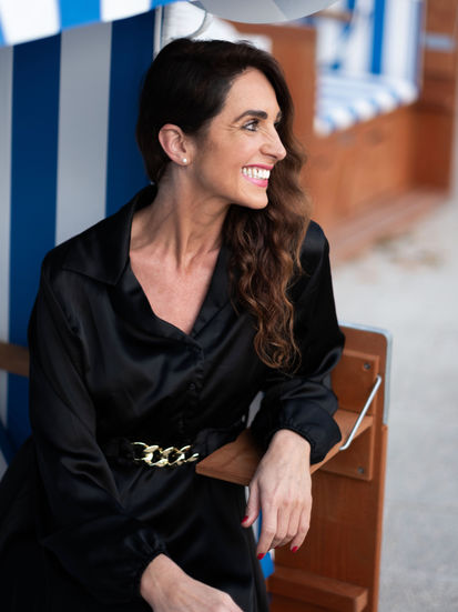 Sarah lachend im Profil im Strandkorb im Kurpark Bad Salzuflen.
