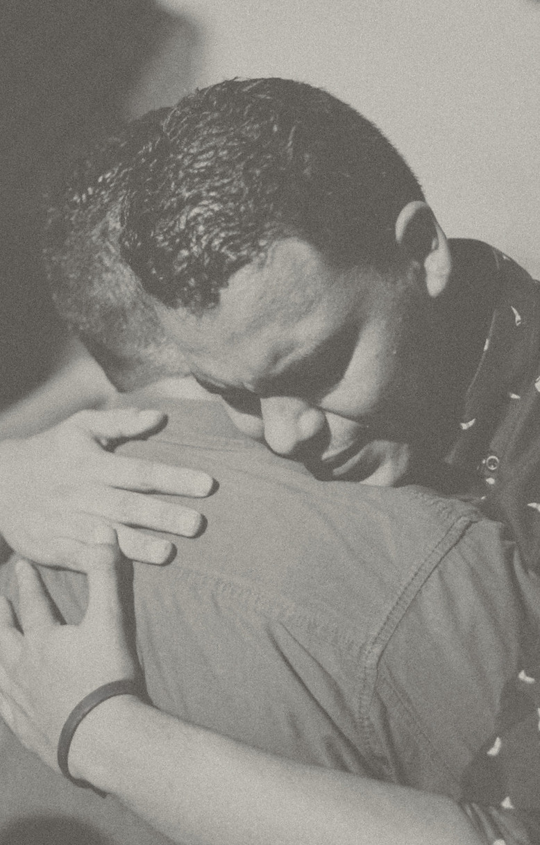 Two individuals exchanging a compassionate hug