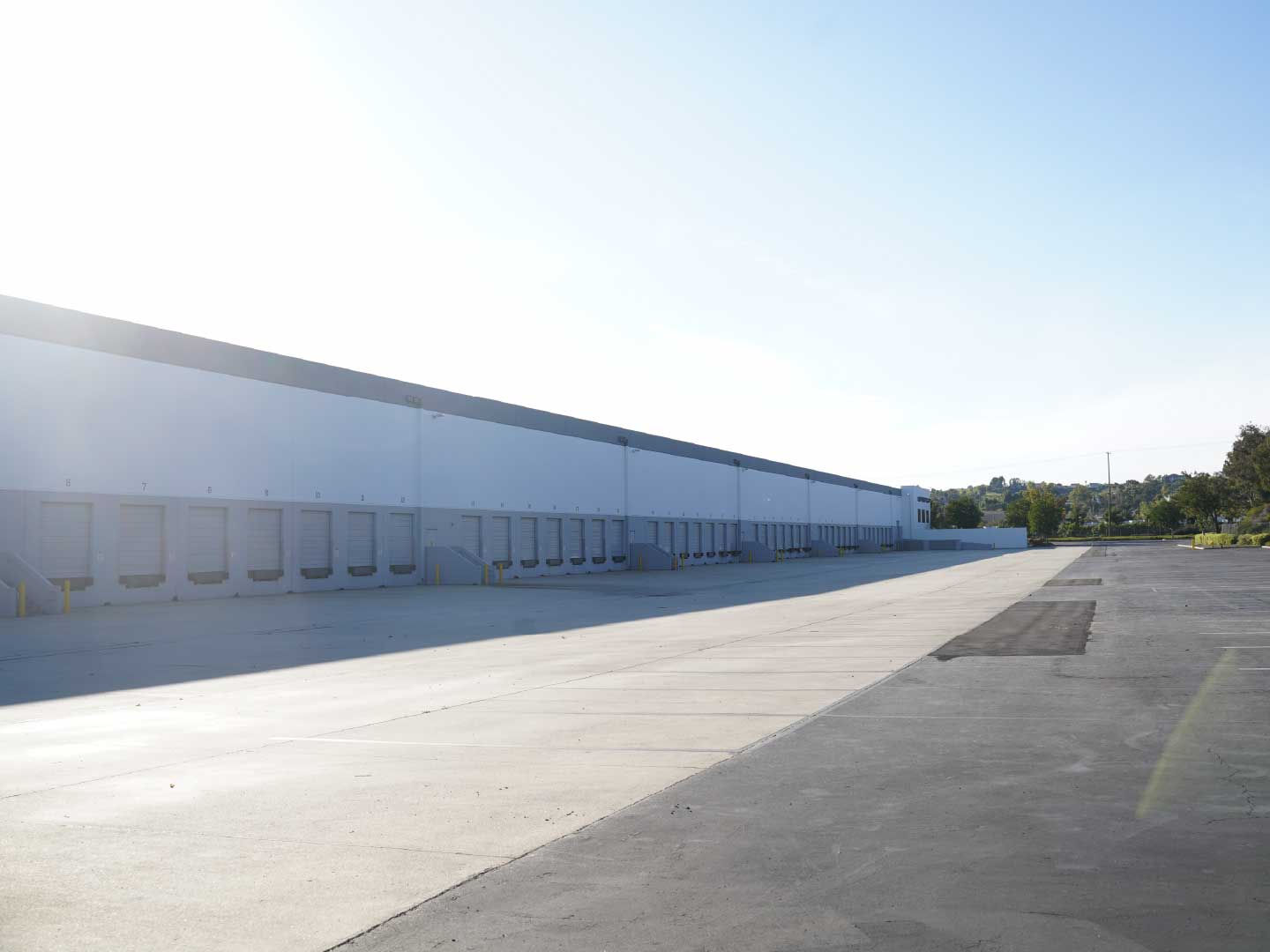 Exterior view of FBD GROUPS warehouse loading docks and spacious truck court engineered for rapid container transport and inventory handling.