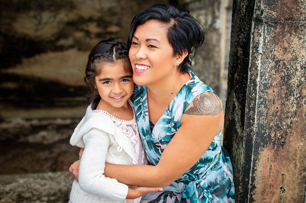 Family photography at Sunset Cliffs in San Diego featuring mother and daughter hugging at sunset