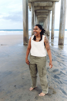 Candid photo of woman laughing during family photo session under Scripps Pier in La Jolla, San Diego