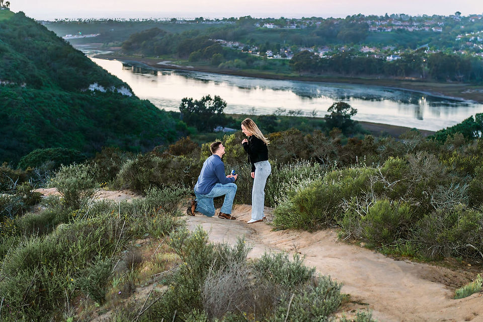 Surprised woman reacts to marriage proposal on hiking trail with San Elijo Lagoon view in Cardiff-by-the-Sea