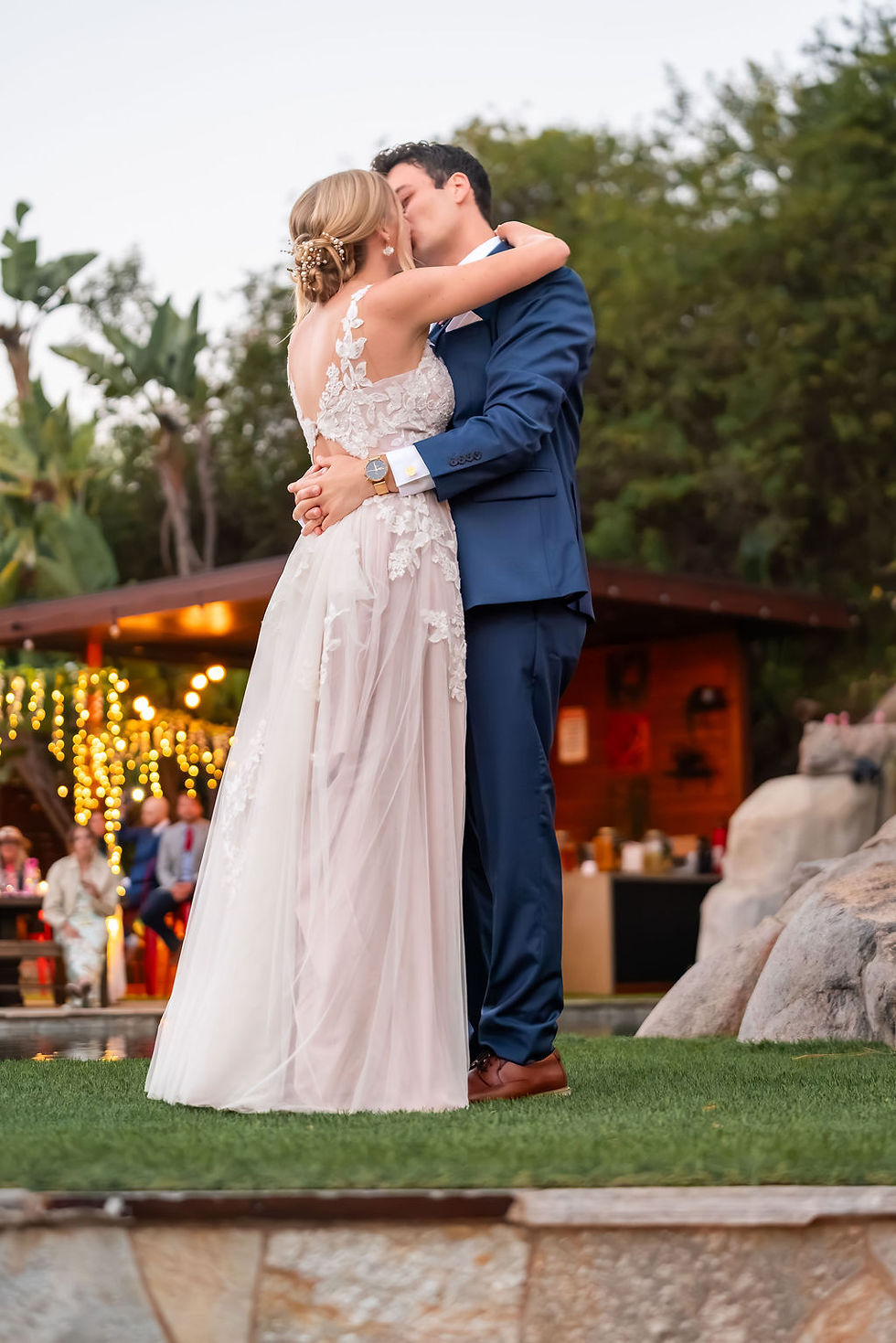 Bride and groom sharing a kiss during romantic first dance on outdoor dance floor at Above the Clouds Estate wedding venue Escondido