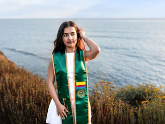 Graduate posing at Sunset Cliffs in San Diego during a senior portrait photography session with the ocean in the background.