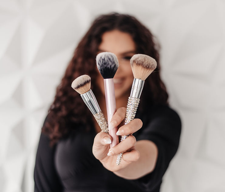 Makeup artist holding brushes