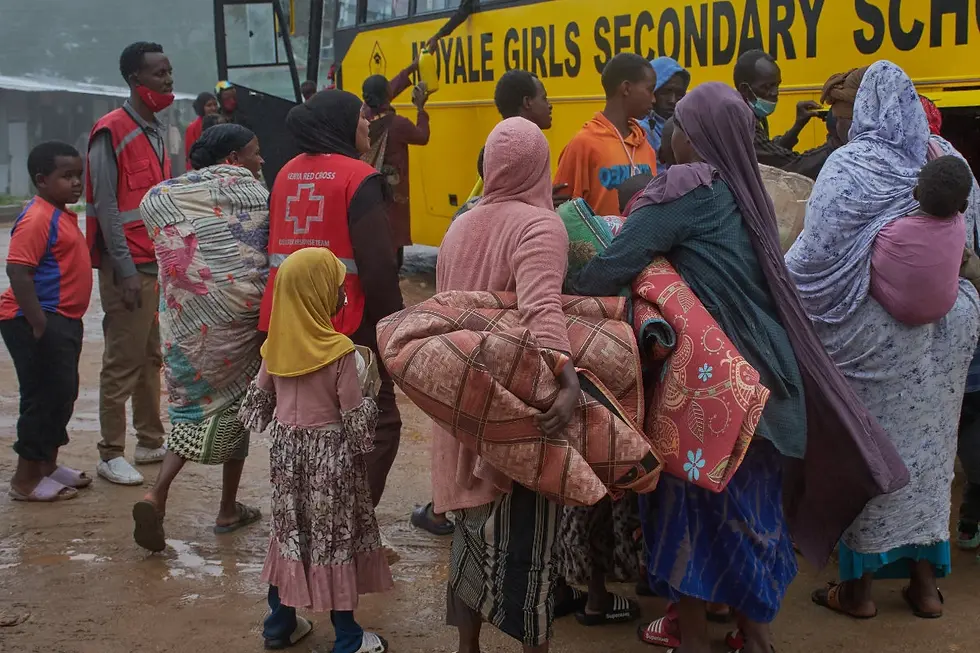 Ethiopian civilians who fled regional fighting disembark from a bus for verification after crossing into Moyale, Kenya, on October 26, 2026.
