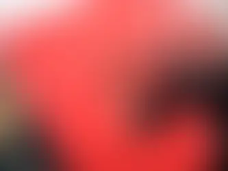 A young woman holds a brigh red sign as they look into the distance.