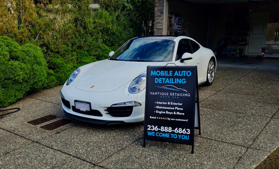 Mobile car detailing in North Delta with Vantique Detailing sign and white Porsche in driveway