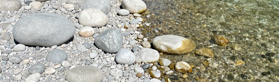 Smooth river stones along a clear water shoreline