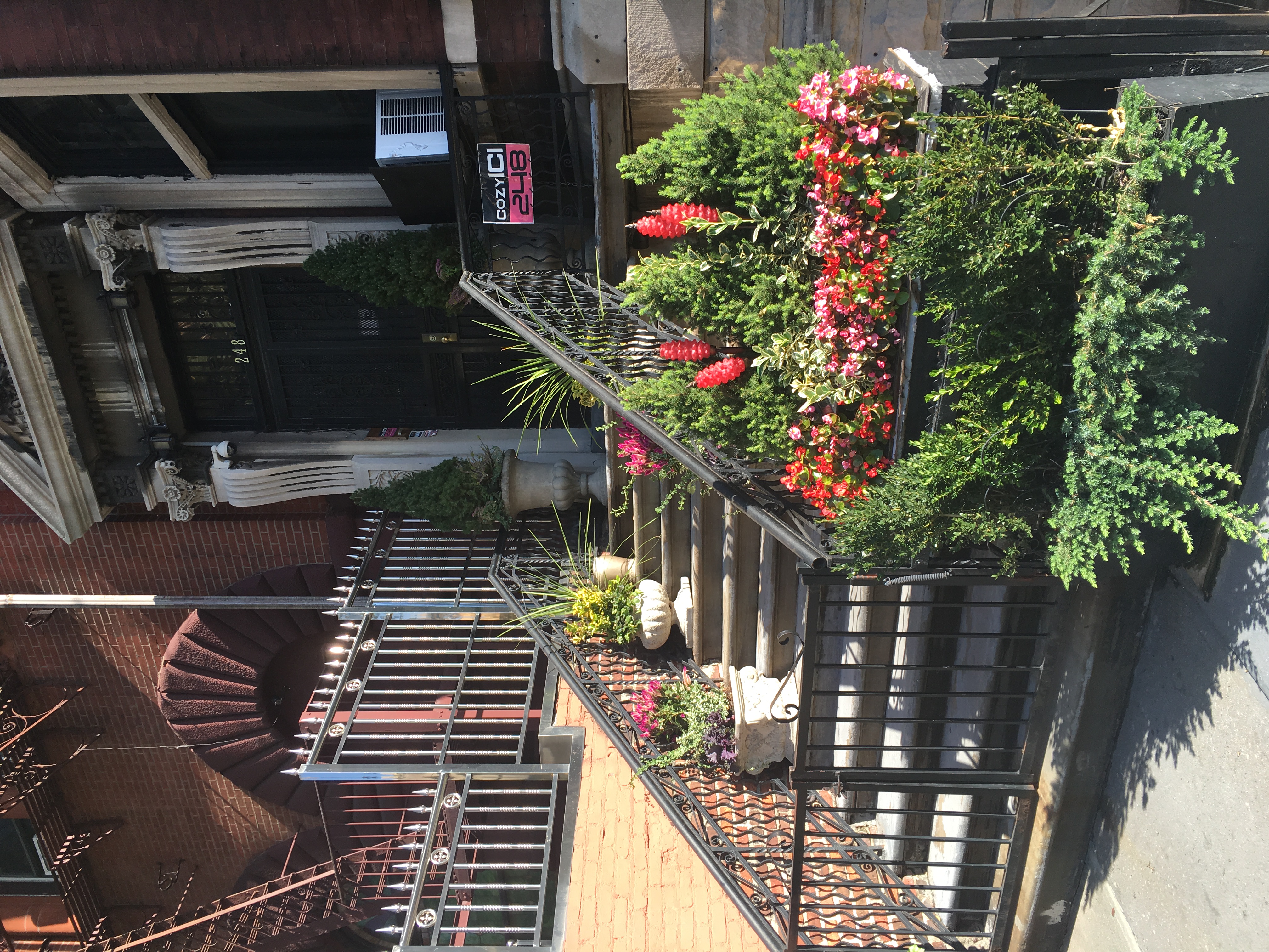 a small exterior staircase with a railing and plants