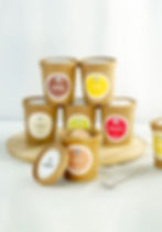 Mehrere Eisbecher in braunen Pappverpackungen mit verschiedenen Geschmacksrichtungen wie Vanille, Schokolade und Himbeere.