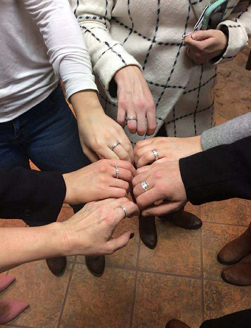 A group of six woman standing in a circle. Only their hands are visible, each of which features a new ring they purchased at an event held at Eternity Jewellery.