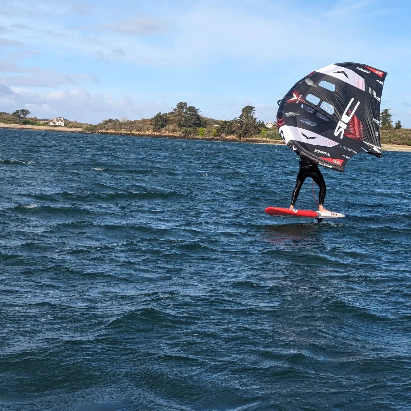 un vol maitrisé pour ce stagiaire en wingfoil dans les eaux de la baie des anges à l'aber wrac'h.