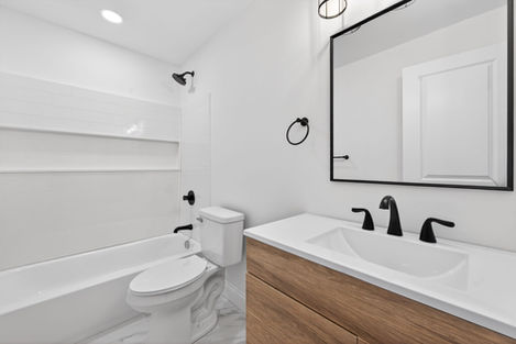 Modern bathroom at 2027 Maury with wood vanity, black fixtures.