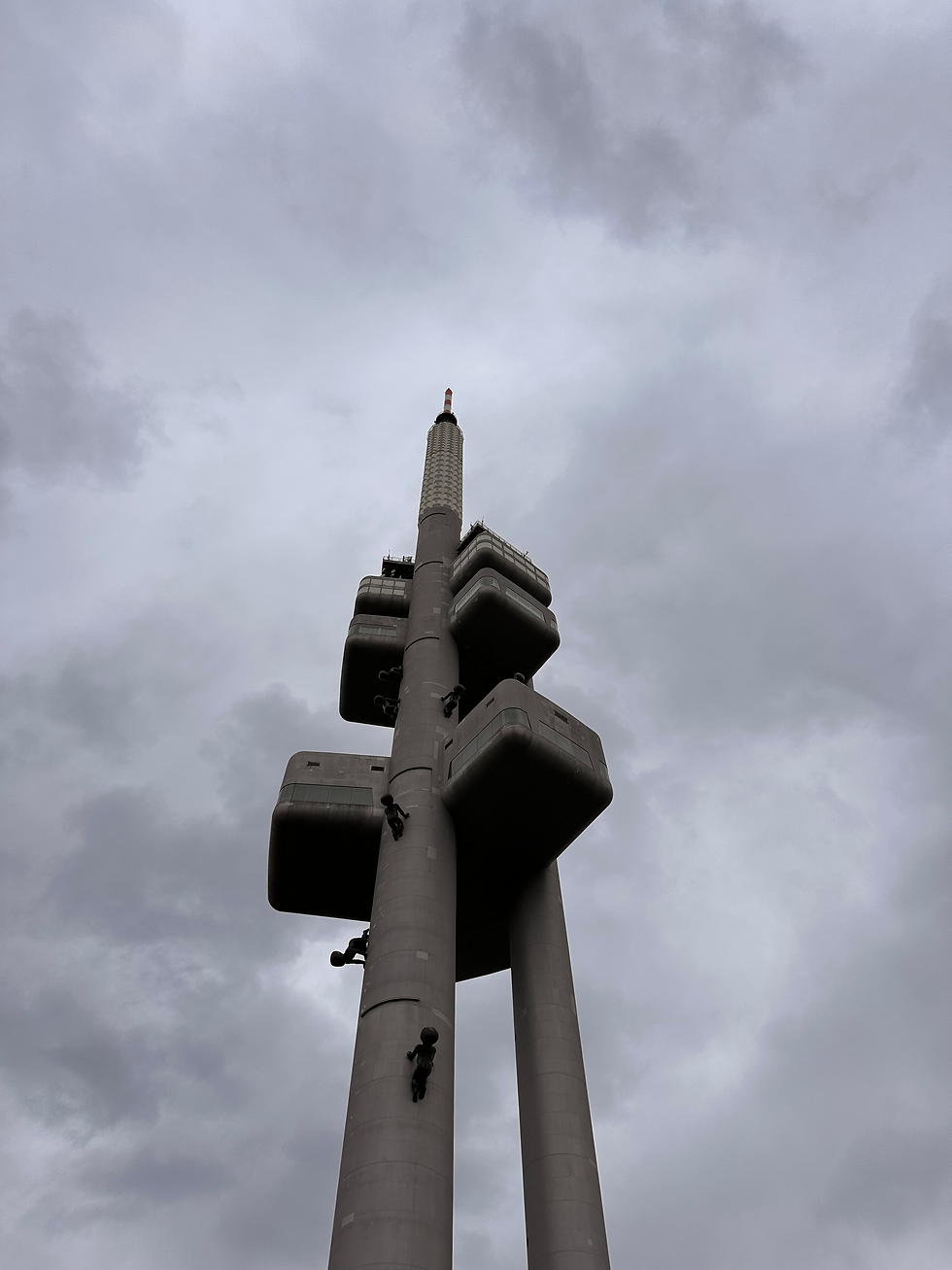 A tower with metal babies statues climbing up and down.