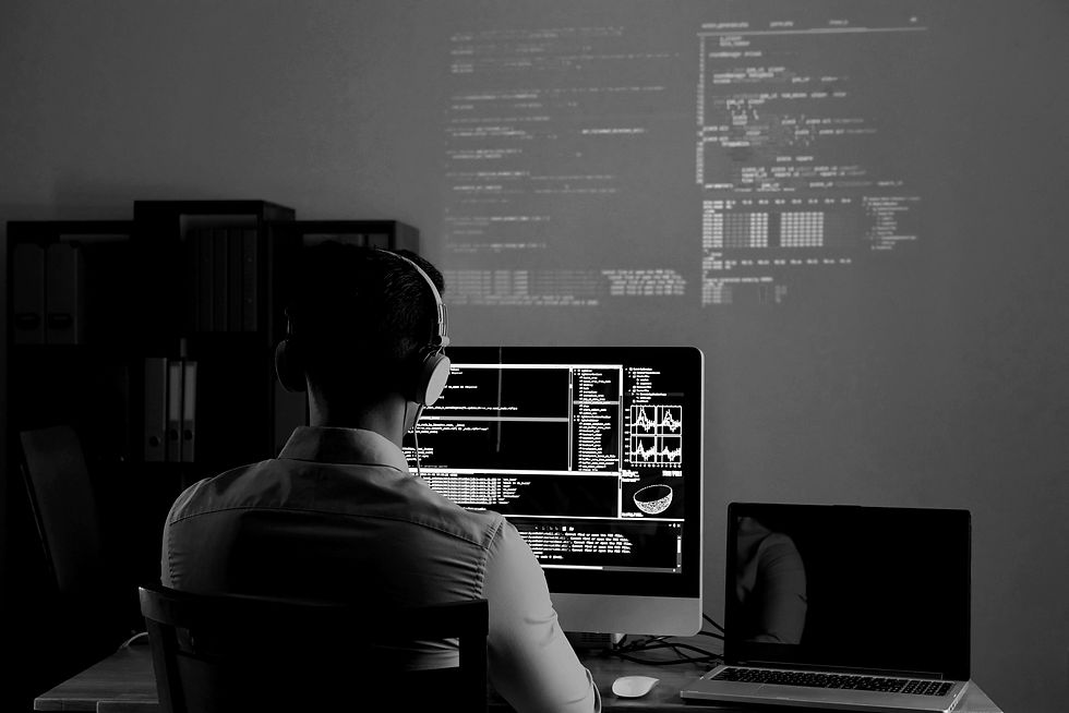 A man in a neon lit room working on a laptop