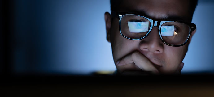 Focused and serious looking man working and thinking hard on computer