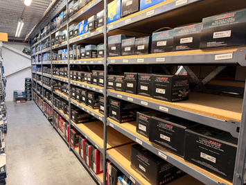 Warehouse shelves stocked with organized automotive parts and inventory boxes