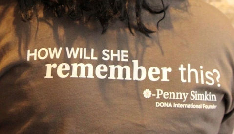 Brown shirt with text “How will she remember this?” quote.