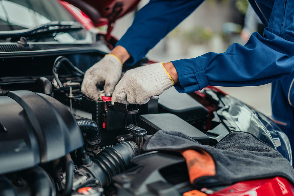 Mechanic inspecting and tightening battery terminal in workshop