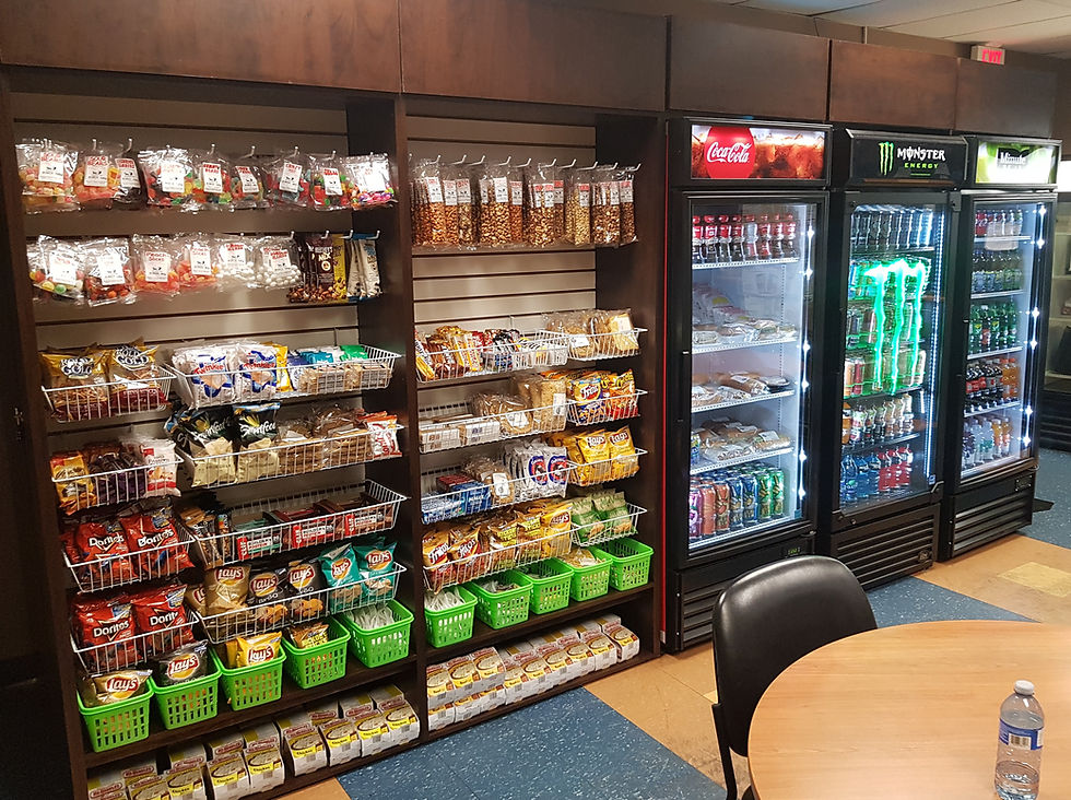 Multiple shelves filled with snacks and refrigerators with soft drinks