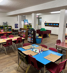 A classroom featuring several tables and chairs arranged for student use