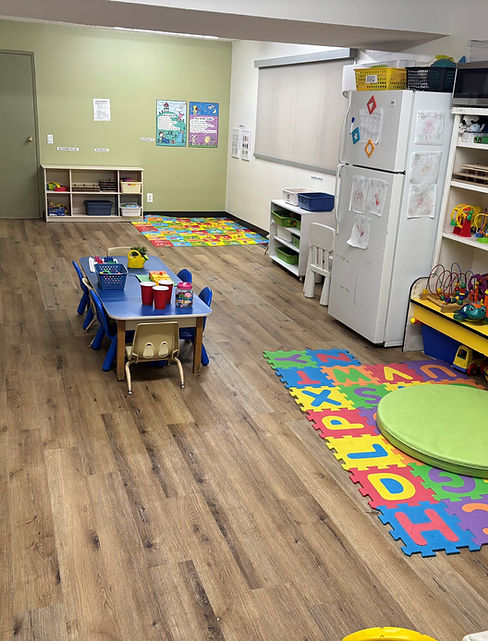 A room featuring a play area with toys and a refrigerator