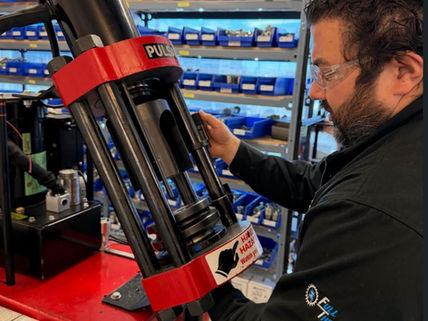 Technician operating coolant exchange machine in automotive service workshop