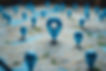 A collection of blue location pins on a map