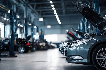 Cars with open hoods in a well-lit mechanic workshop