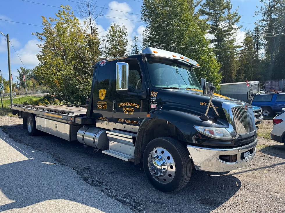 Black heavy-duty tow truck parked during sunny daytime