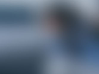 Focus of woman sitting and covering face with hands in bedroom