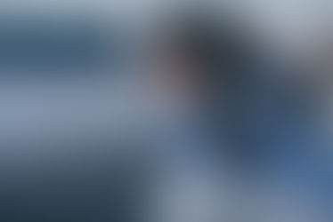 Focus of woman sitting and covering face with hands in bedroom