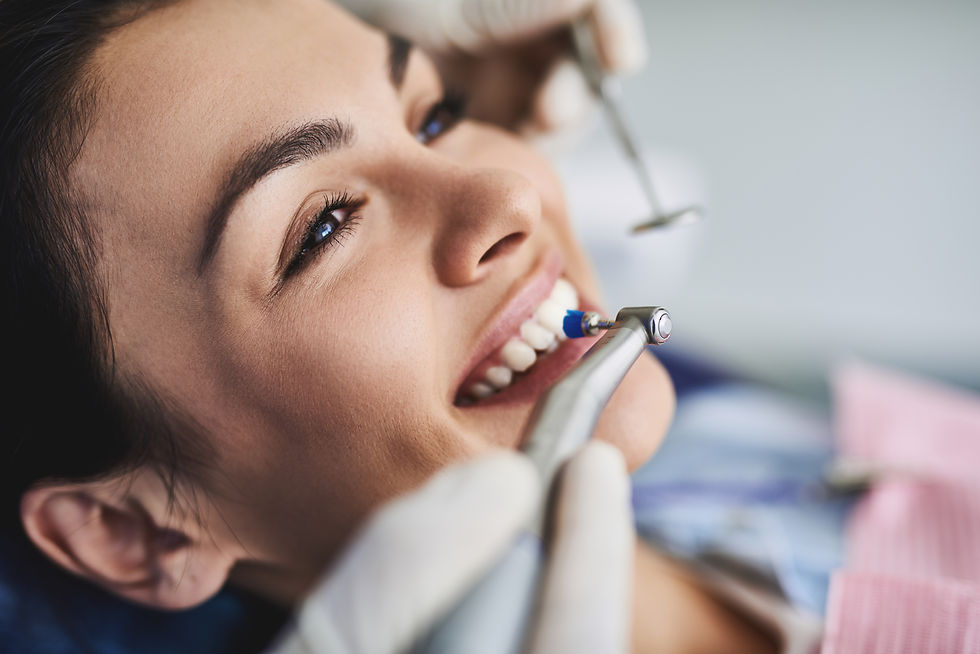 Charming young lady receiving teeth cleaning and polishing at clinic