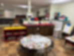 A round table in classroom with full of students artwork