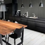Beautiful kitchen with black cabinets and chairs with a table in between