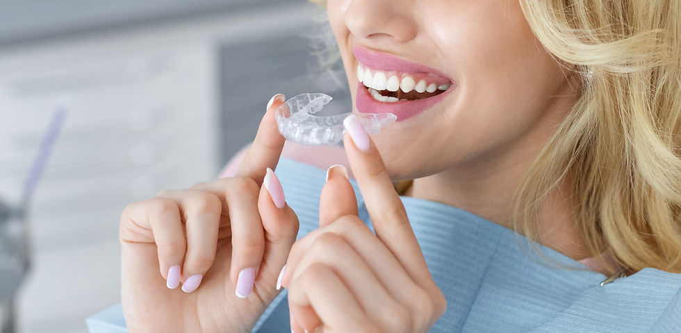 Unrecognizable blonde woman with healthy white teeth holding invisible braces while sitting at dental chair