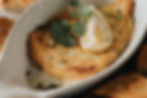 A golden, flaky fish fillet garnished with lemon and fresh cilantro