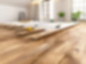 Worker Installing Hardwood Flooring in Bright Room