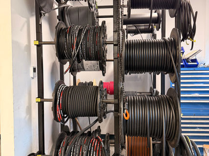 Wire spool storage rack organized with automotive electrical cable rolls