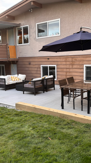 Finished concrete patio furnished with outdoor seating and dark umbrella
