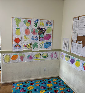 An interior view of a classroom showcasing a bulletin board and a cozy rug
