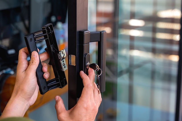 Close up locksmith installing handle door lock key on mirror door