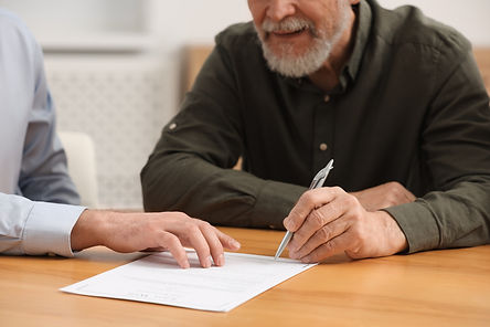 Notary showing senior man where to sign Last Will