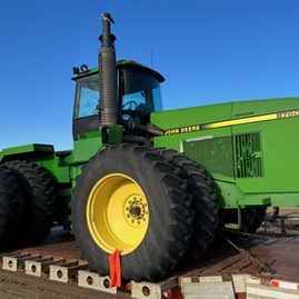 A large tractor parked on a flatbed trailer, ready for transport.