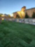 A backyard featuring artificial turf, a wooden fence, and decorative Armour Stone elements enhancing