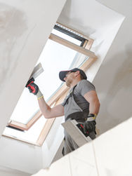 A person applying drywall