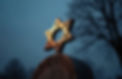Jewish gravestone with Star of David symbol at cemetery at dusk