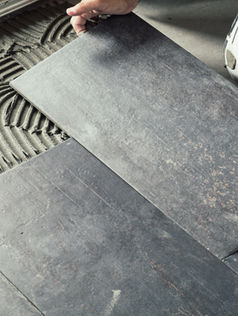A person laying out ceramic floor tiles