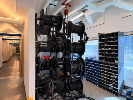 Industrial wire spool rack with organized automotive cable inventory